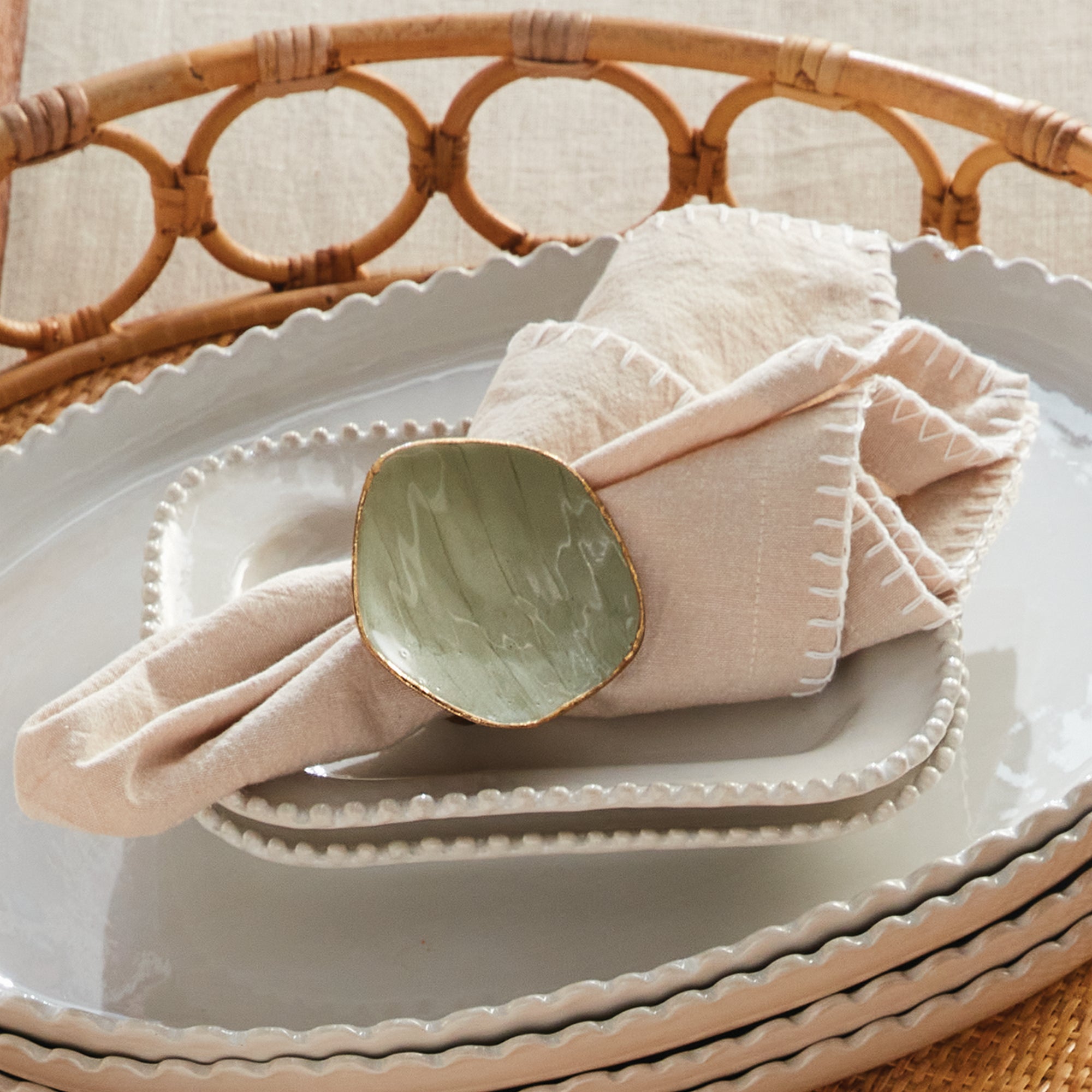 Complete table setting featuring a folded cloth napkin and a stylish ring