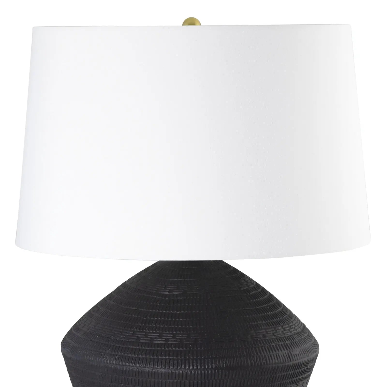 Table lamp with a black textured base and white shade on a white background
