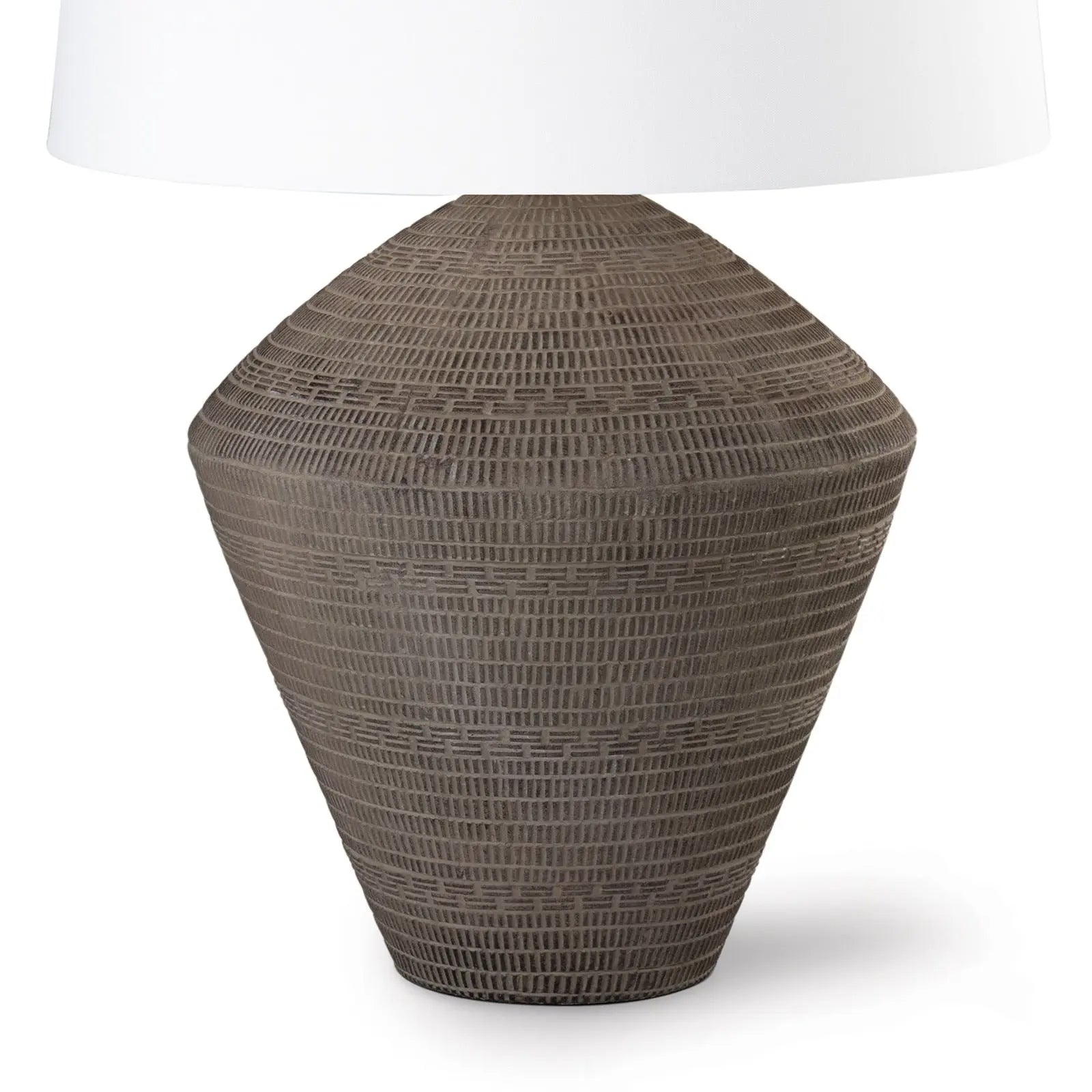 Textured table lamp with a white shade on a white background