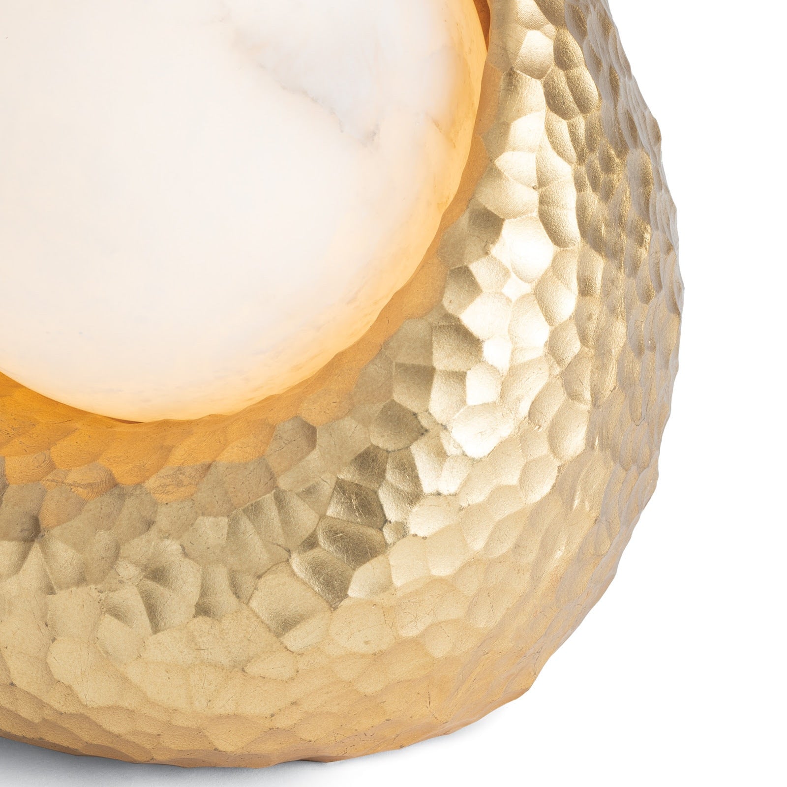 Nest Mini Lamp, a small decorative light fixture with an intricate gold resin hammered base and a round, soft glowing alabaster sphere.