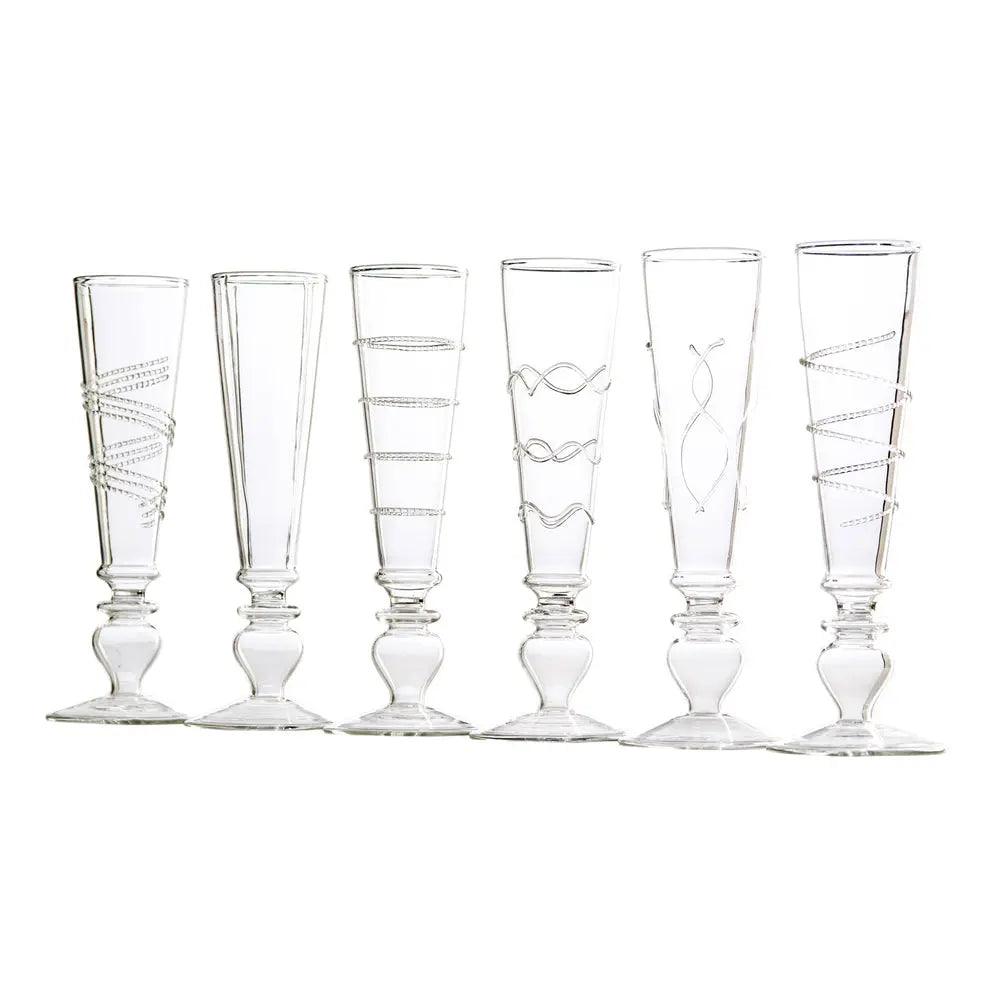 A set of six elegant Razzle Dazzle champagne flutes with clear accents and a footed base, arranged on a luxurious dining table.