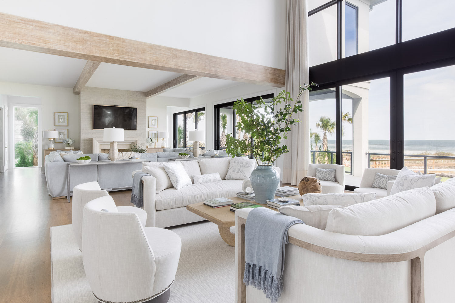 Cyber Week Sale - Modern living room with white furniture and large windows overlooking a scenic view.