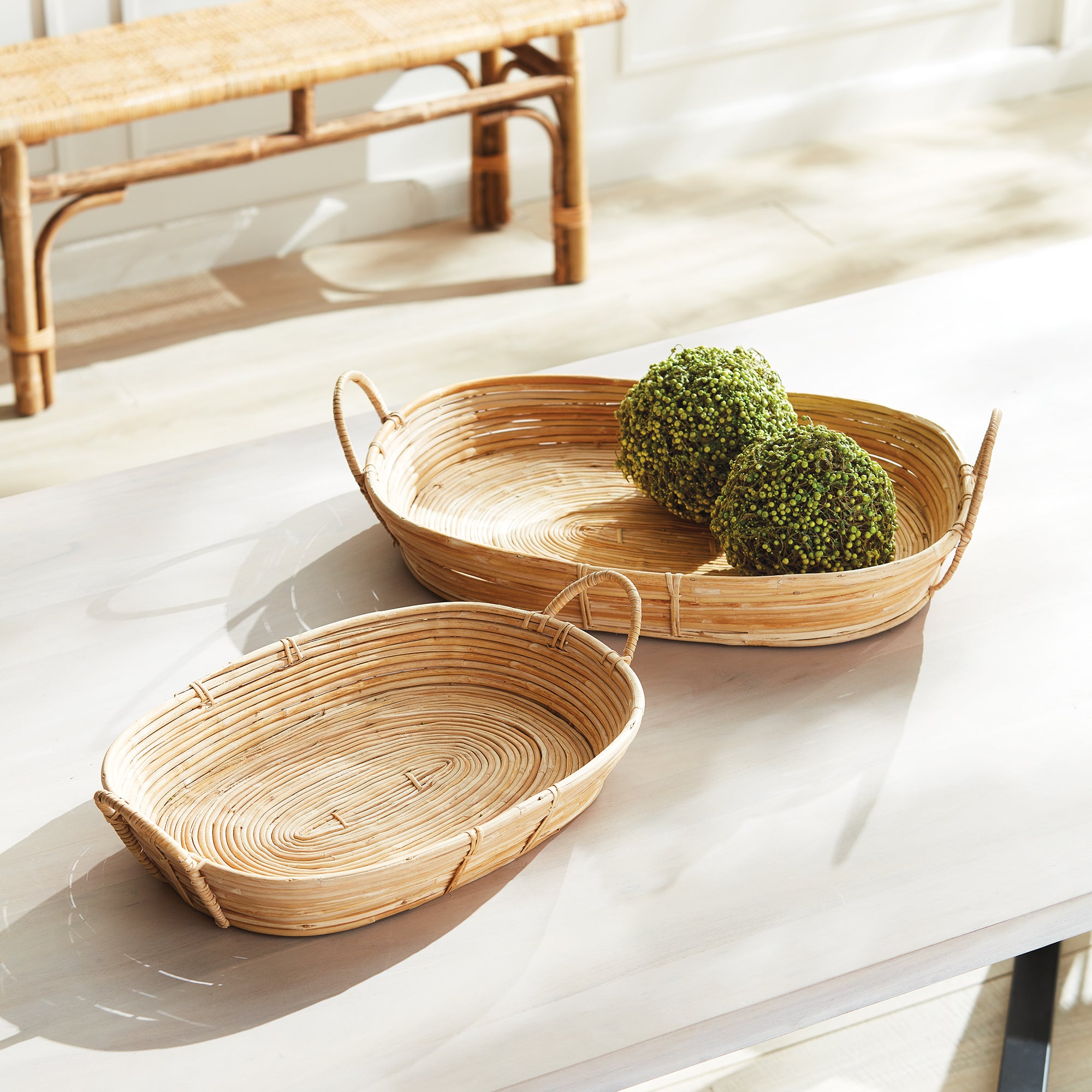 Two woven baskets on a white surface with a blurred background