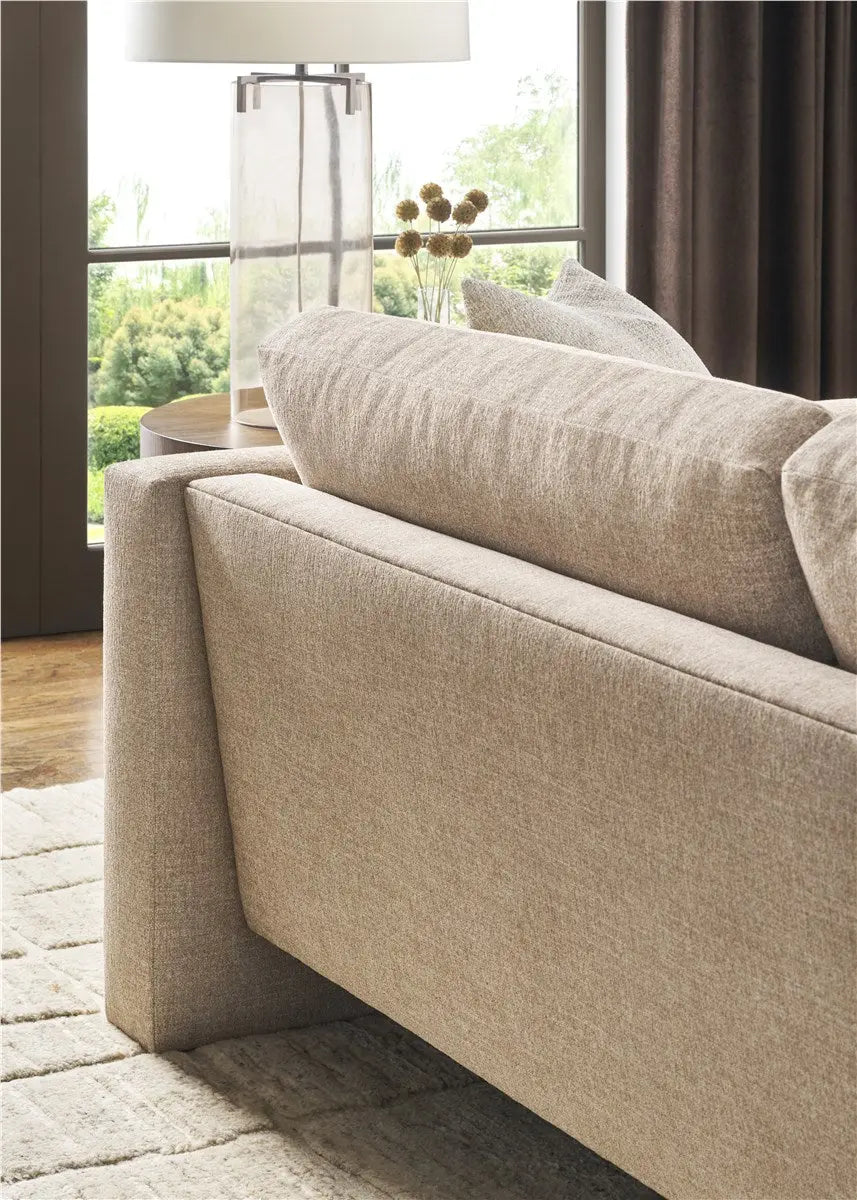 A modern 95-inch Brady Sofa with a unique suspended floating base and track arms, upholstered in textured light gray Jumpy Burlap performance fabric.