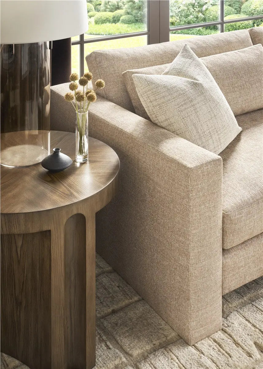 A modern 95-inch Brady Sofa with a unique suspended floating base and track arms, upholstered in textured light gray Jumpy Burlap performance fabric.