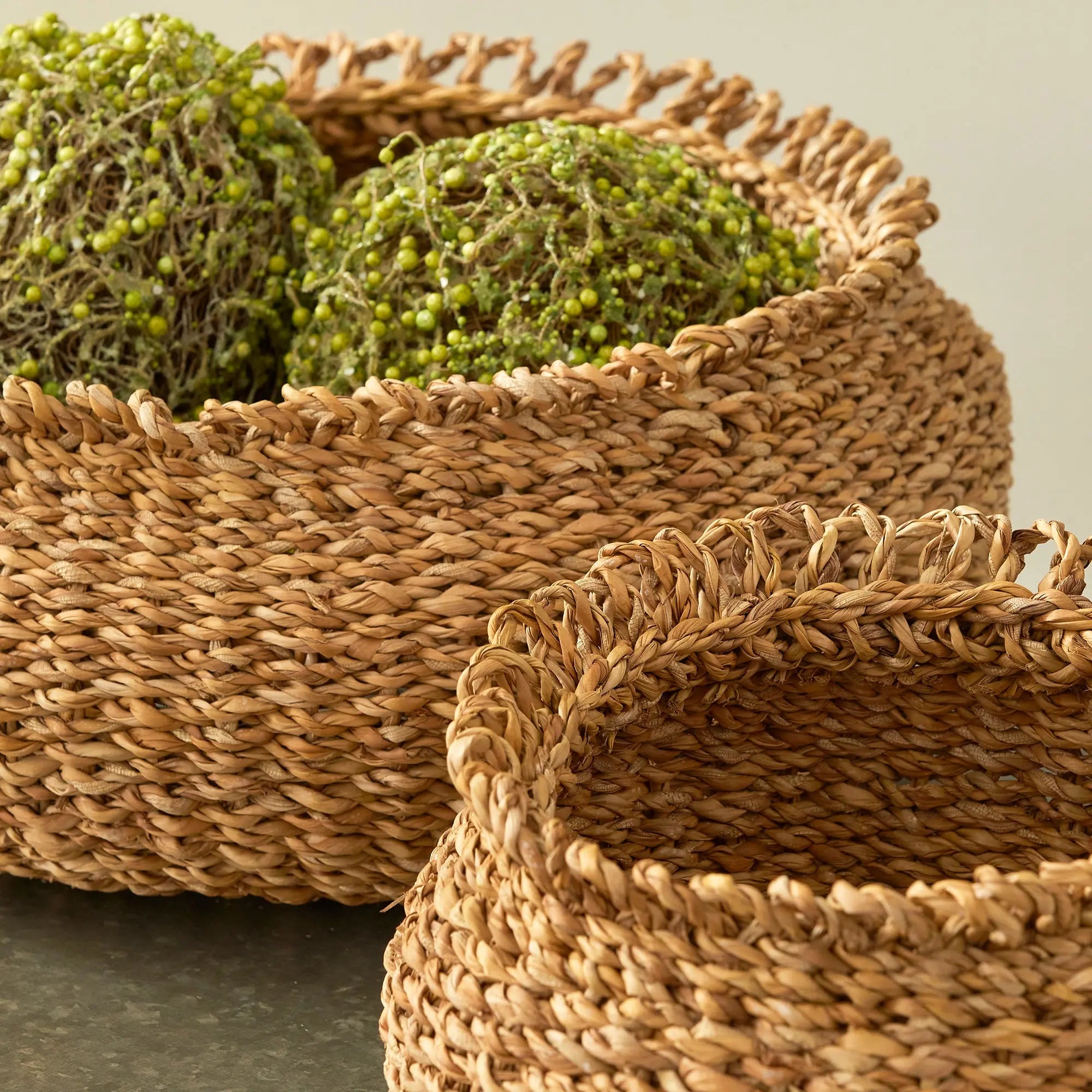 Woven baskets with greenery on a neutral background