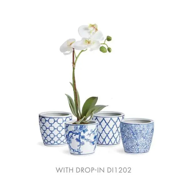 Set of four blue and white patterned pots with a white orchid on a white background
