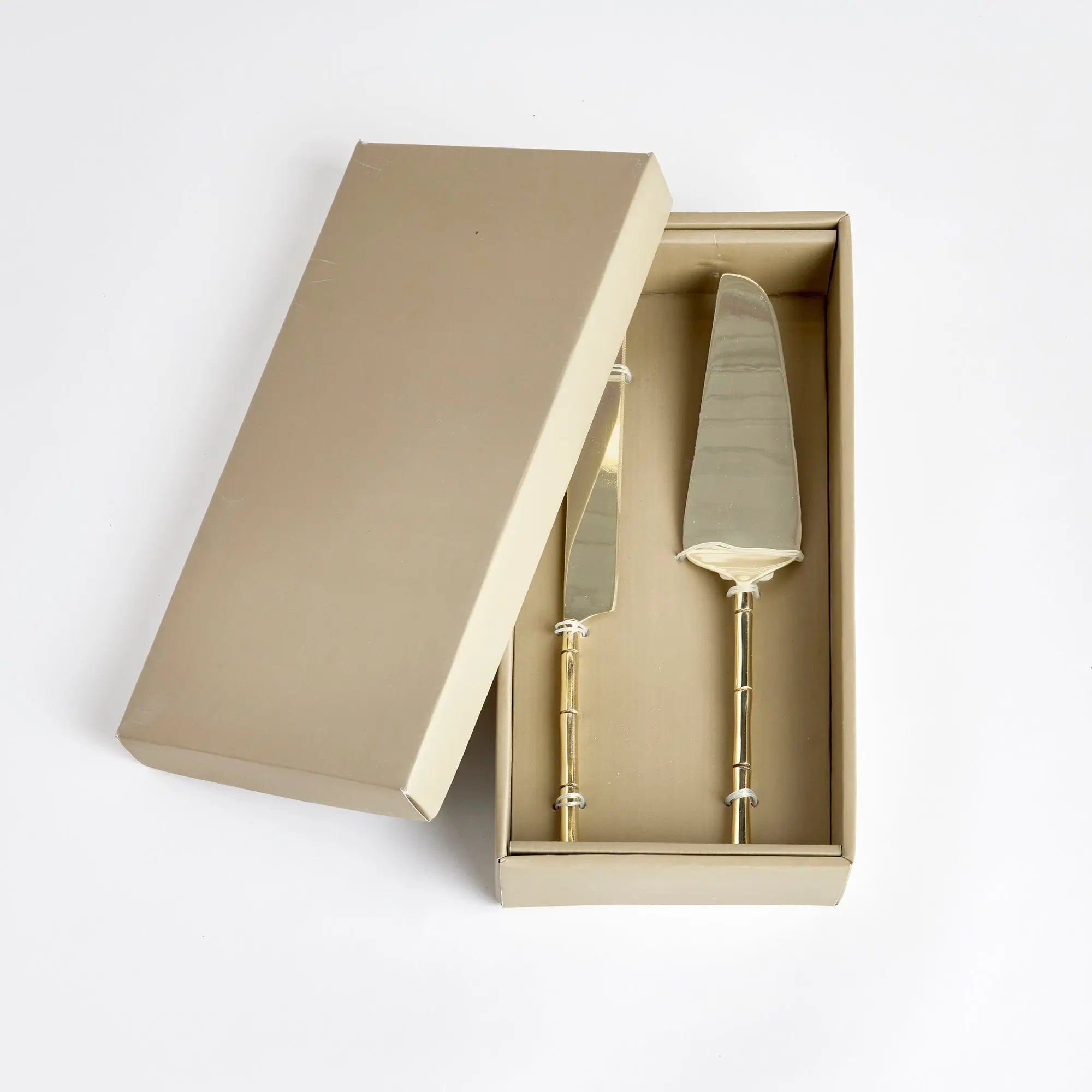 Stainless steel Grove dessert servers inside open retail gift box