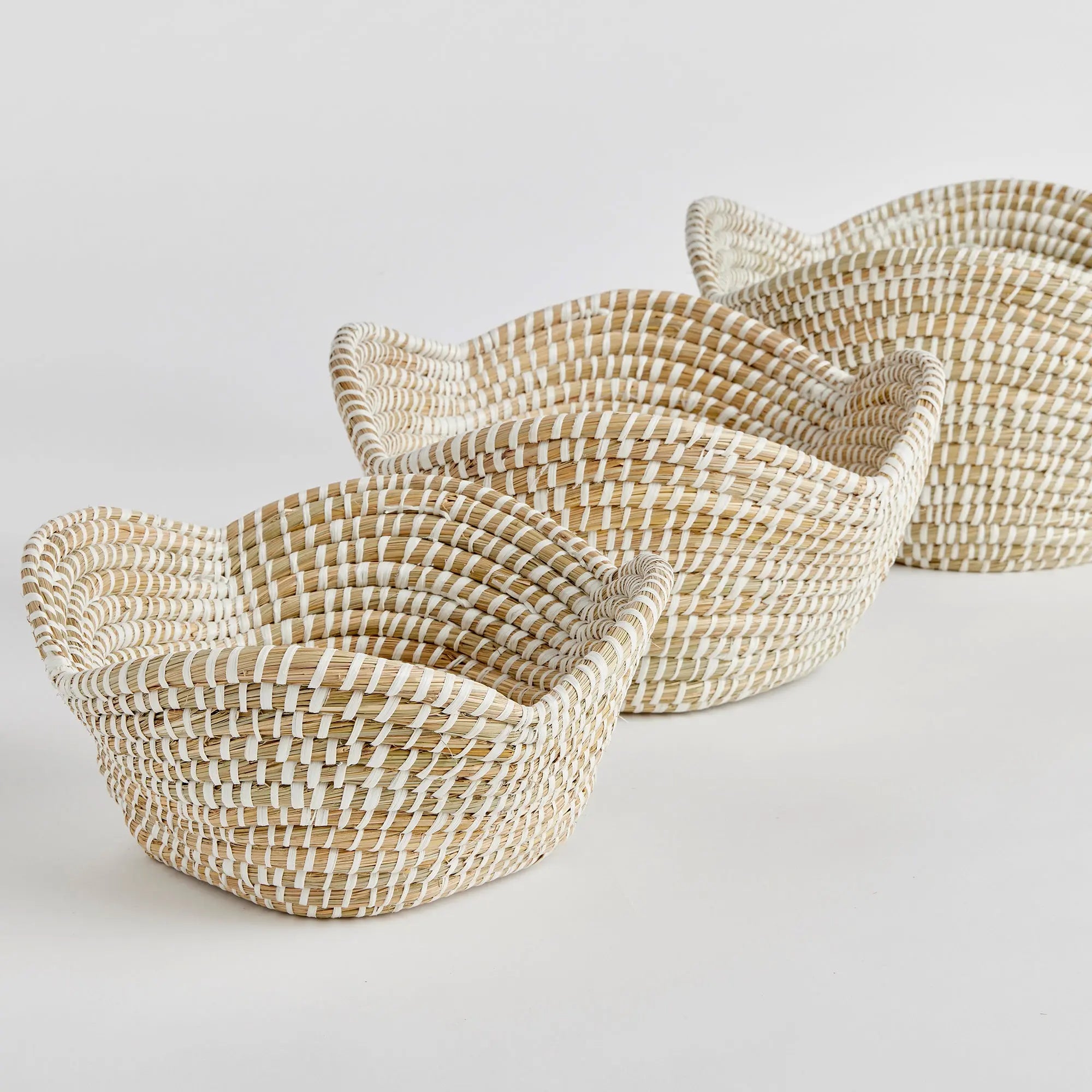 Three woven baskets of different sizes on a light gray background