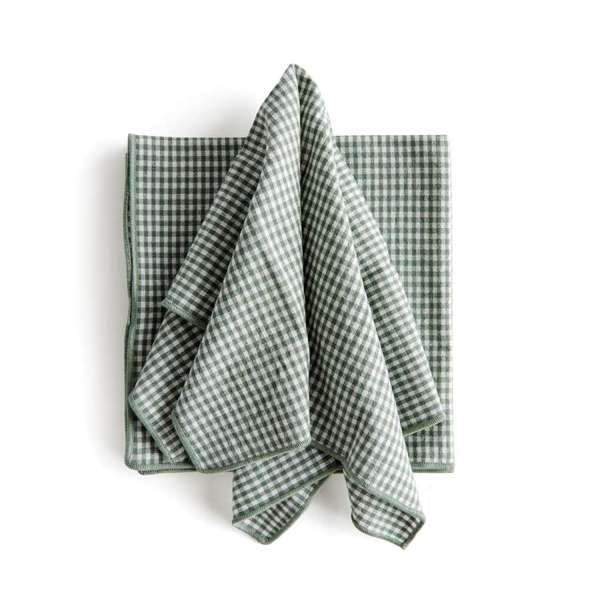 Set of four Viola Dinner Napkins made from soft, verdant green cotton, folded and tied with a grosgrain ribbon.