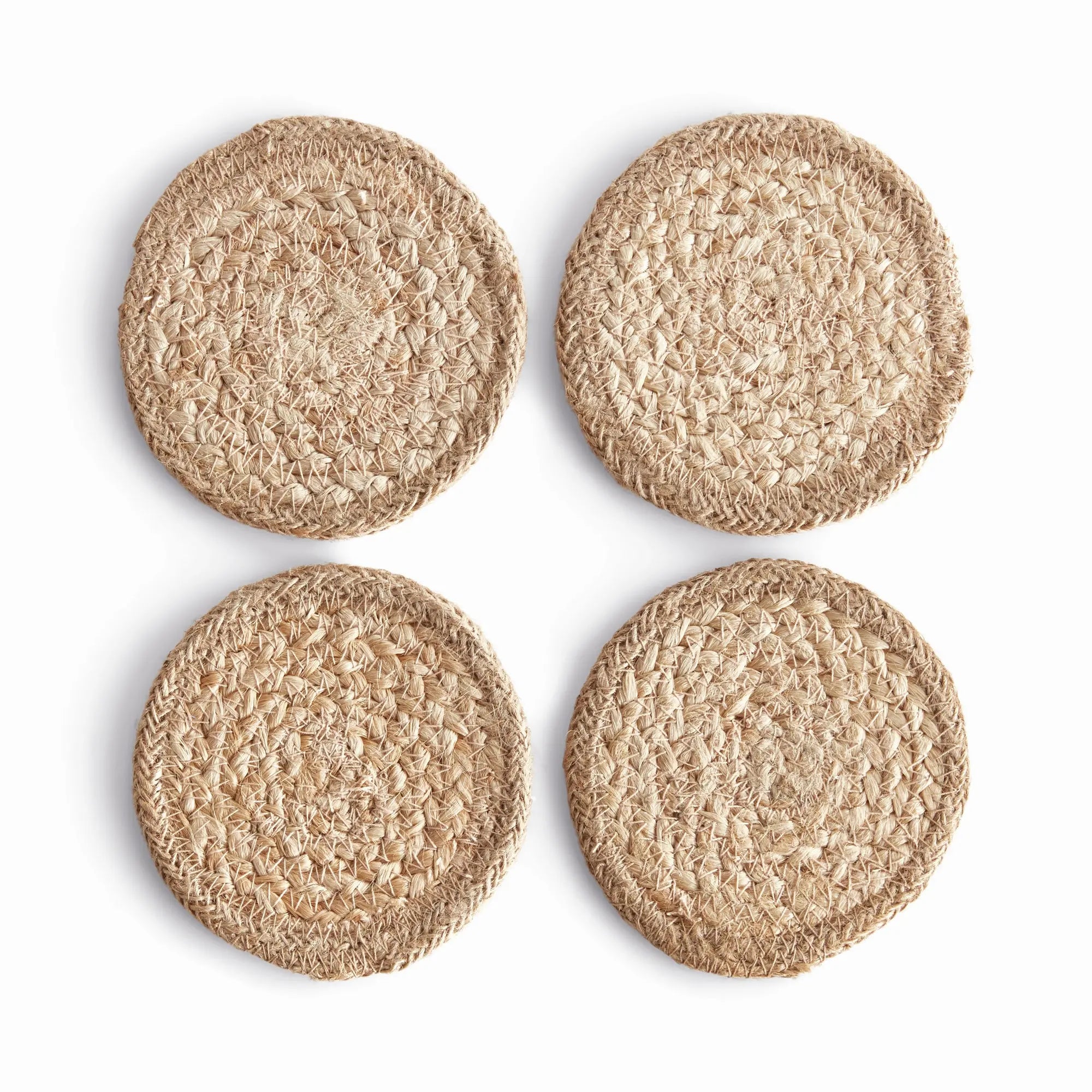 Four round woven coasters on a white background
