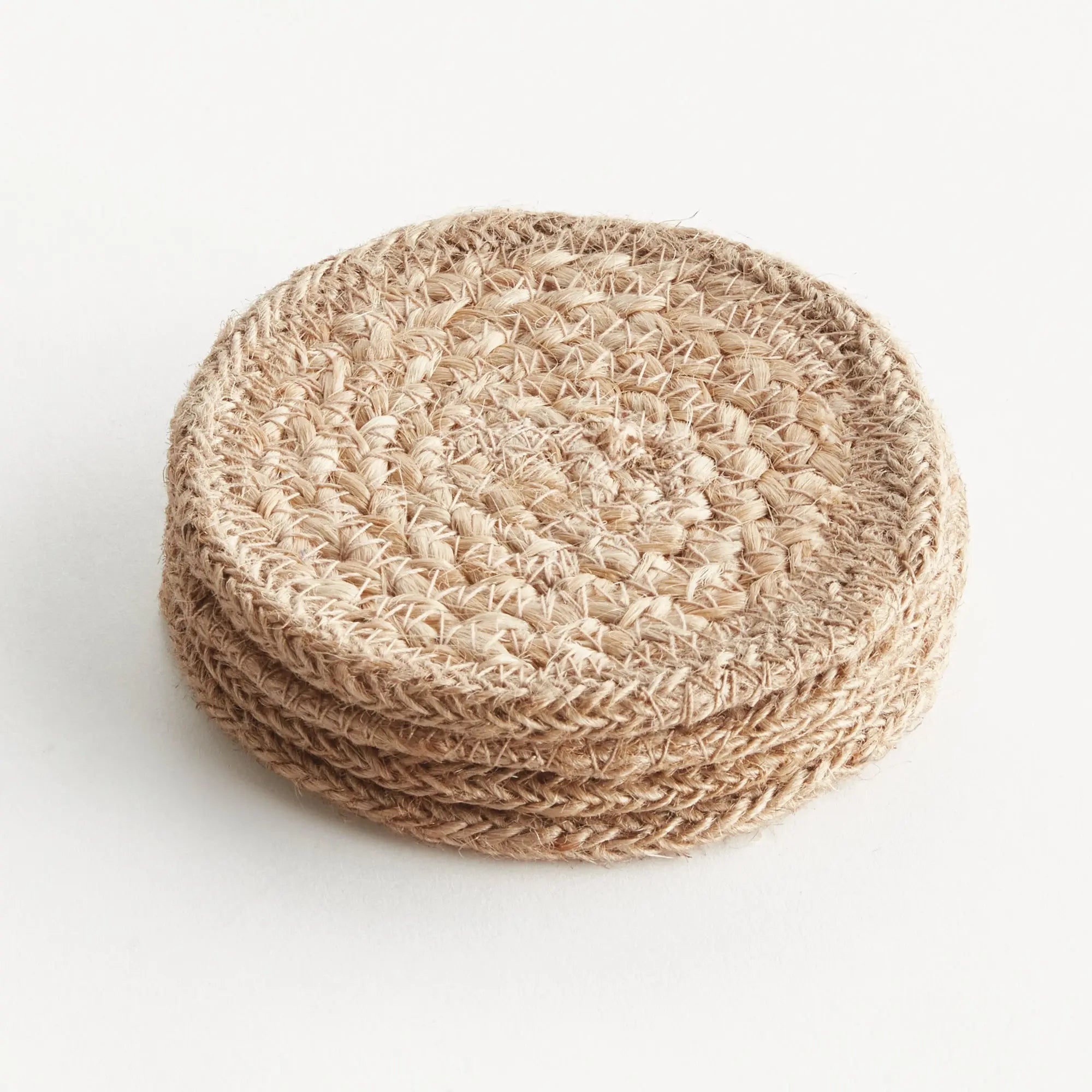 Stack of beige crocheted coasters on a white background