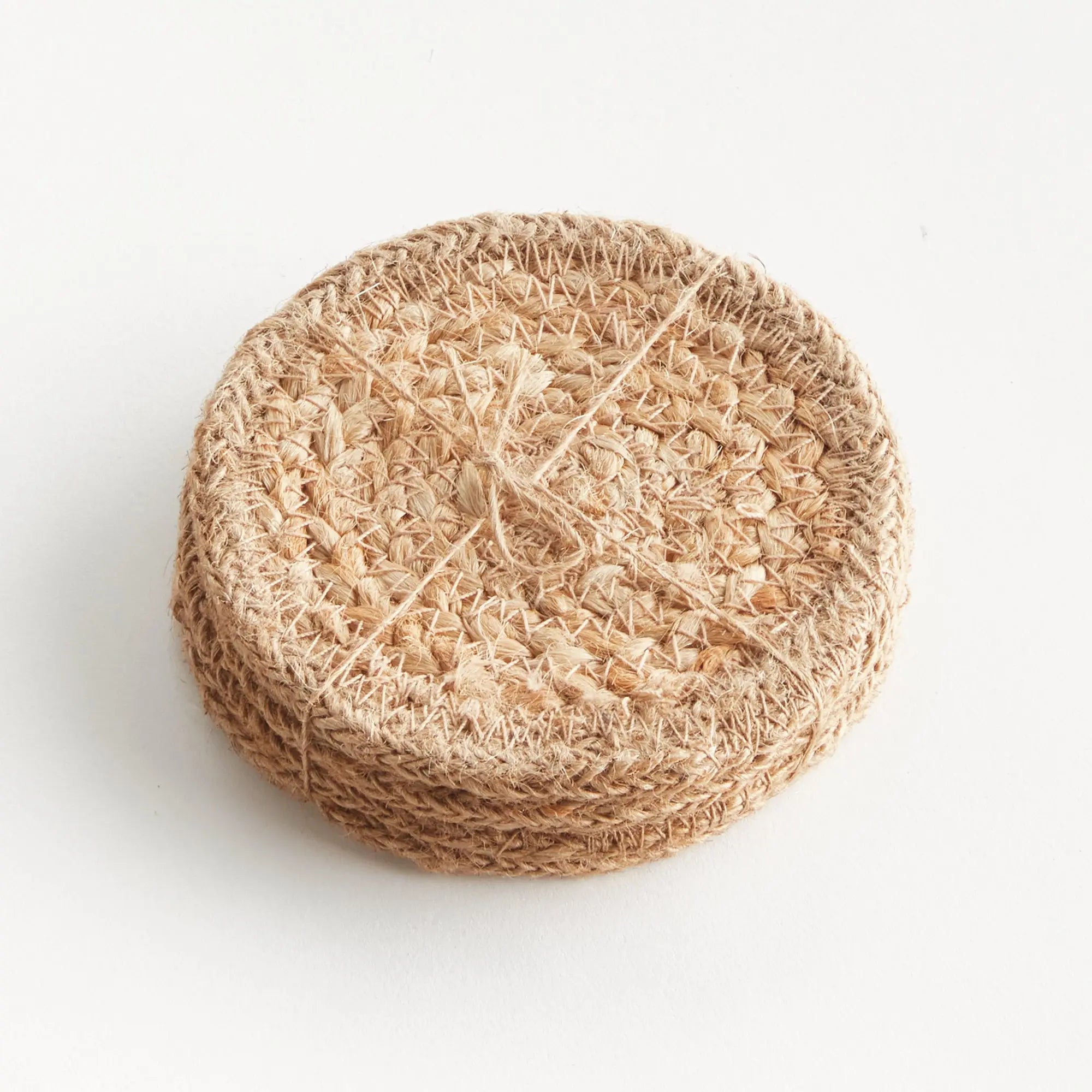 Round beige loofah sponge on a white background