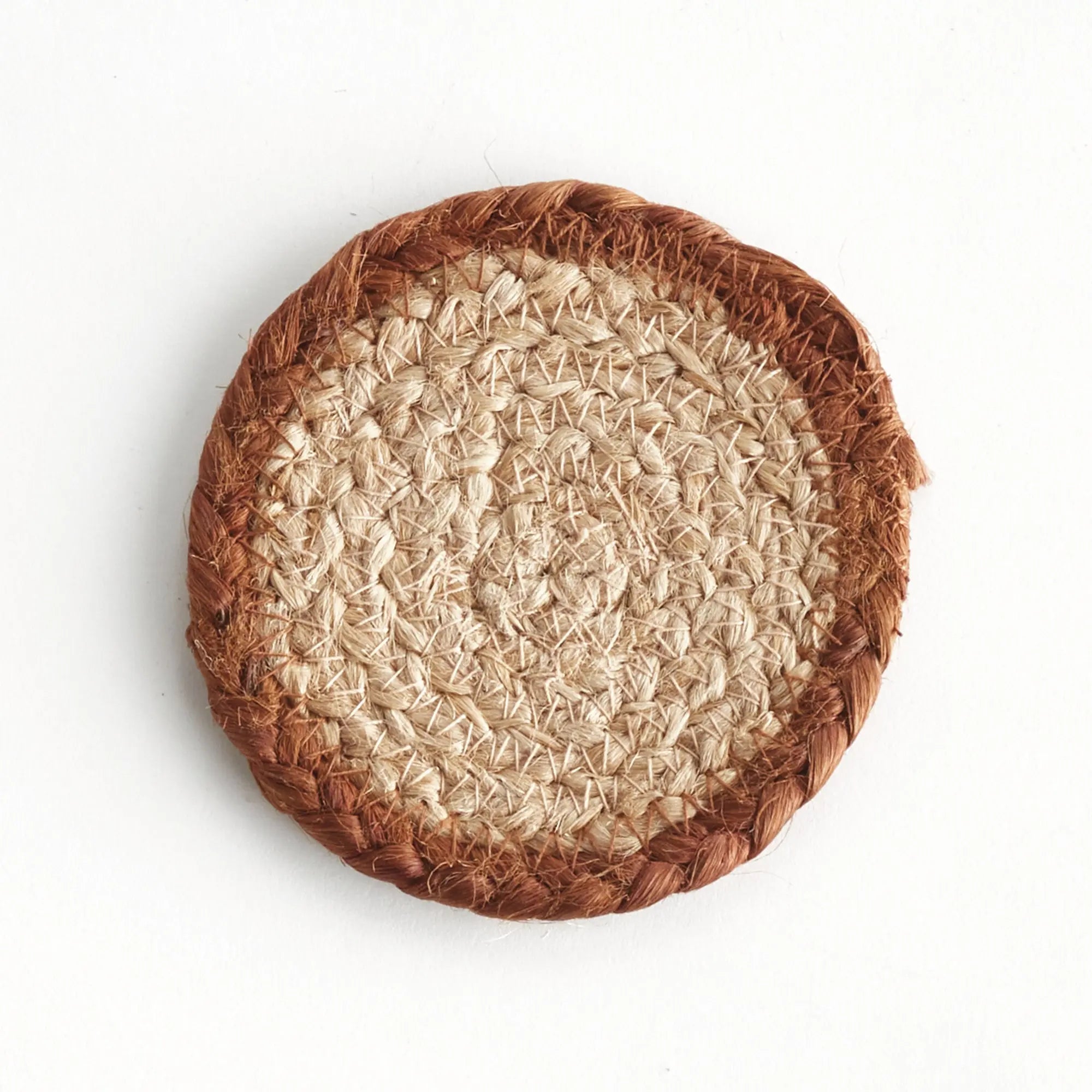 Round woven mat with brown rim and beige center on a white background