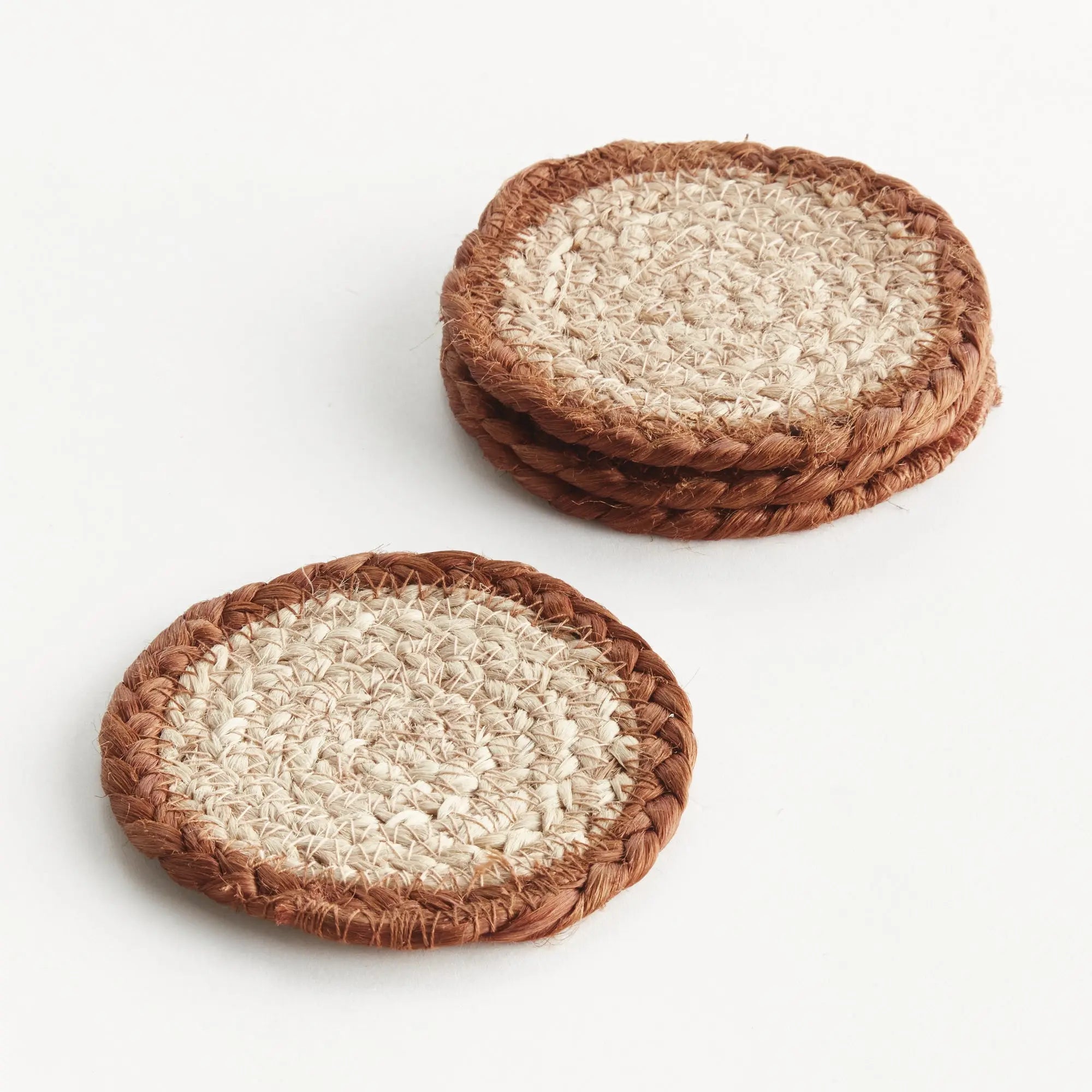Two woven coasters with a natural fiber surface on a white background