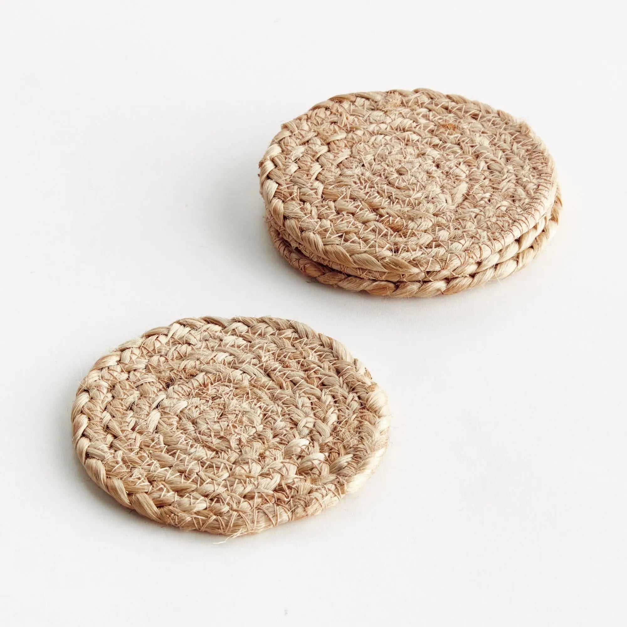 Two woven round coasters on a white background
