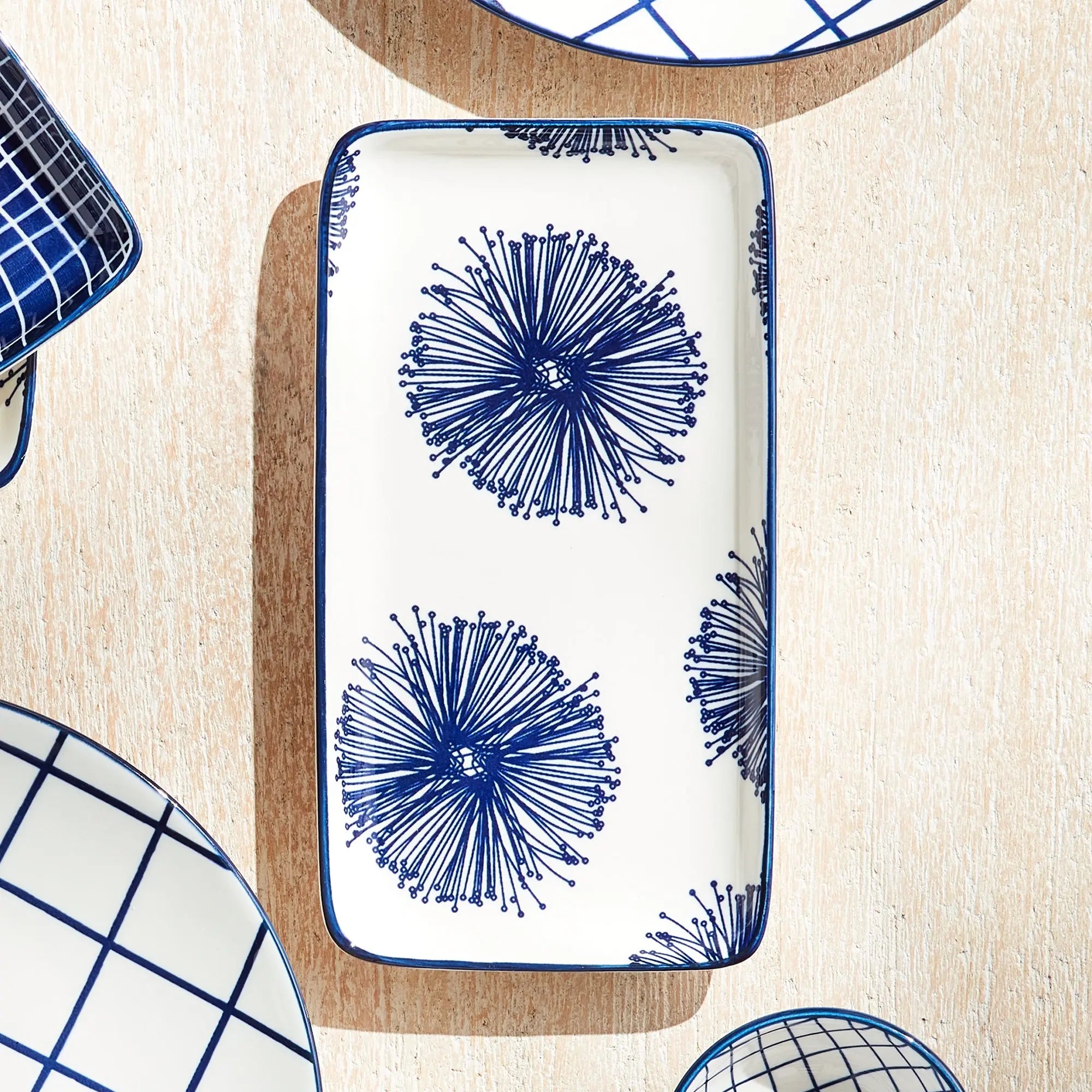 Stria Starburst 8" Trays Set of 4 - dark blue and white ceramic serving trays with starburst radiating pattern for appetizers and entertaining