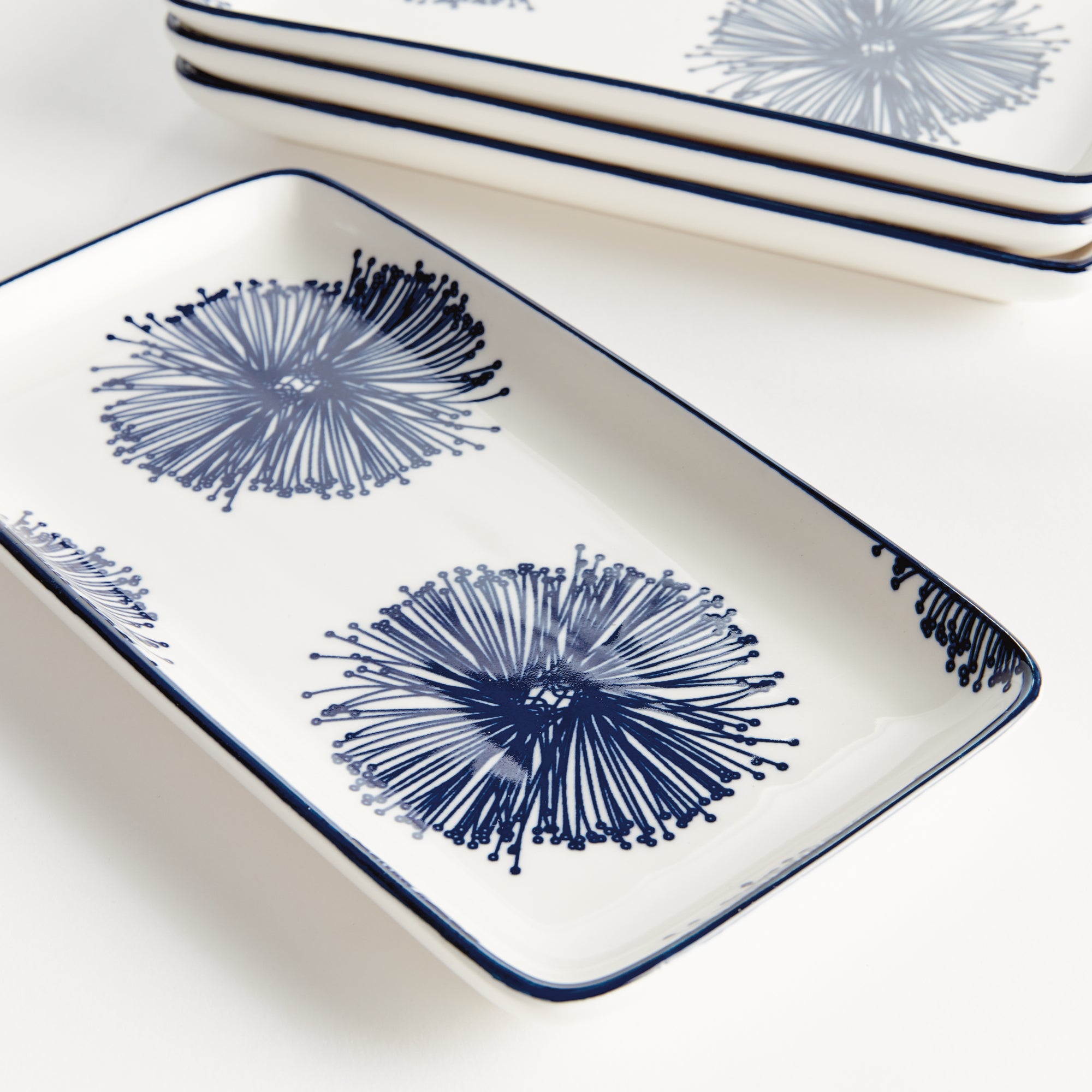 Stria Starburst 8" Trays Set of 4 - dark blue and white ceramic serving trays with starburst radiating pattern for appetizers and entertaining