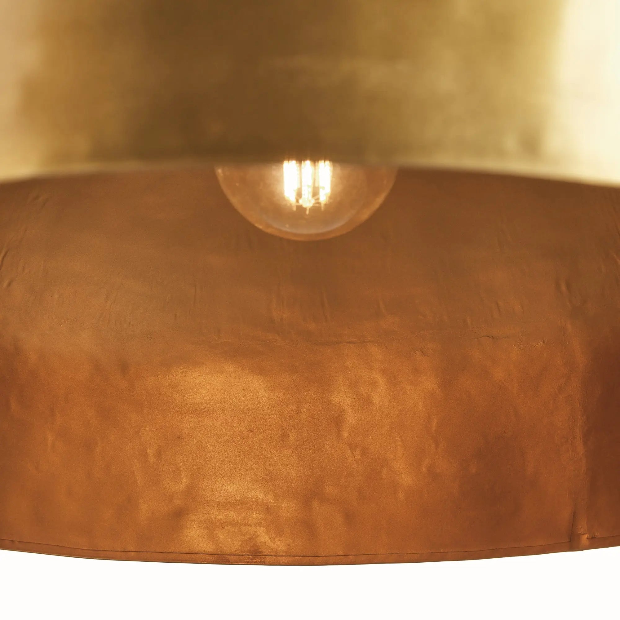 Close-up of a textured brown lampshade with a visible light bulb.