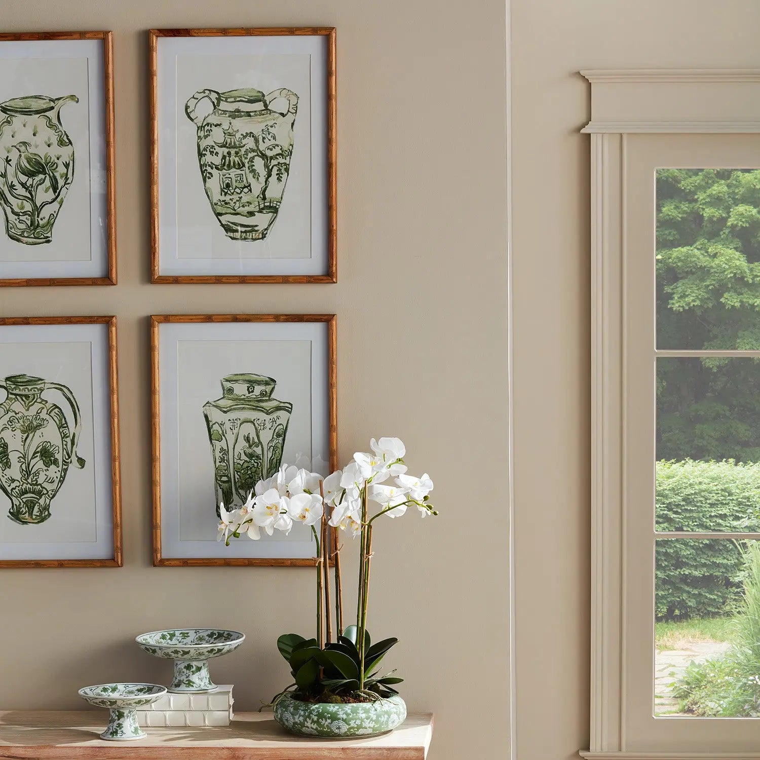 A set of four matted wall art prints featuring traditional chinoiserie jars in a monochromatic green color, encased in light-toned natural Chinese fir wood frames with glass.
