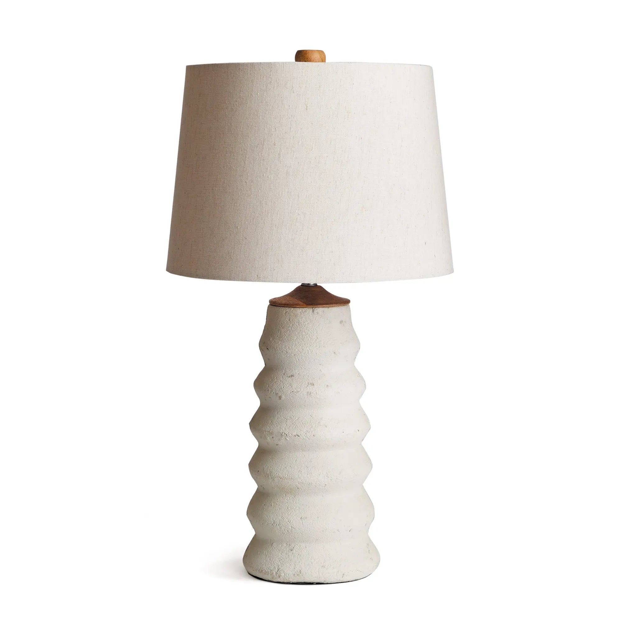 Adria Table Lamp with a textured, pitted, warm white ecomix base and a cream-colored tapered lamp shade. The lamp is shown from the front against a neutral background.