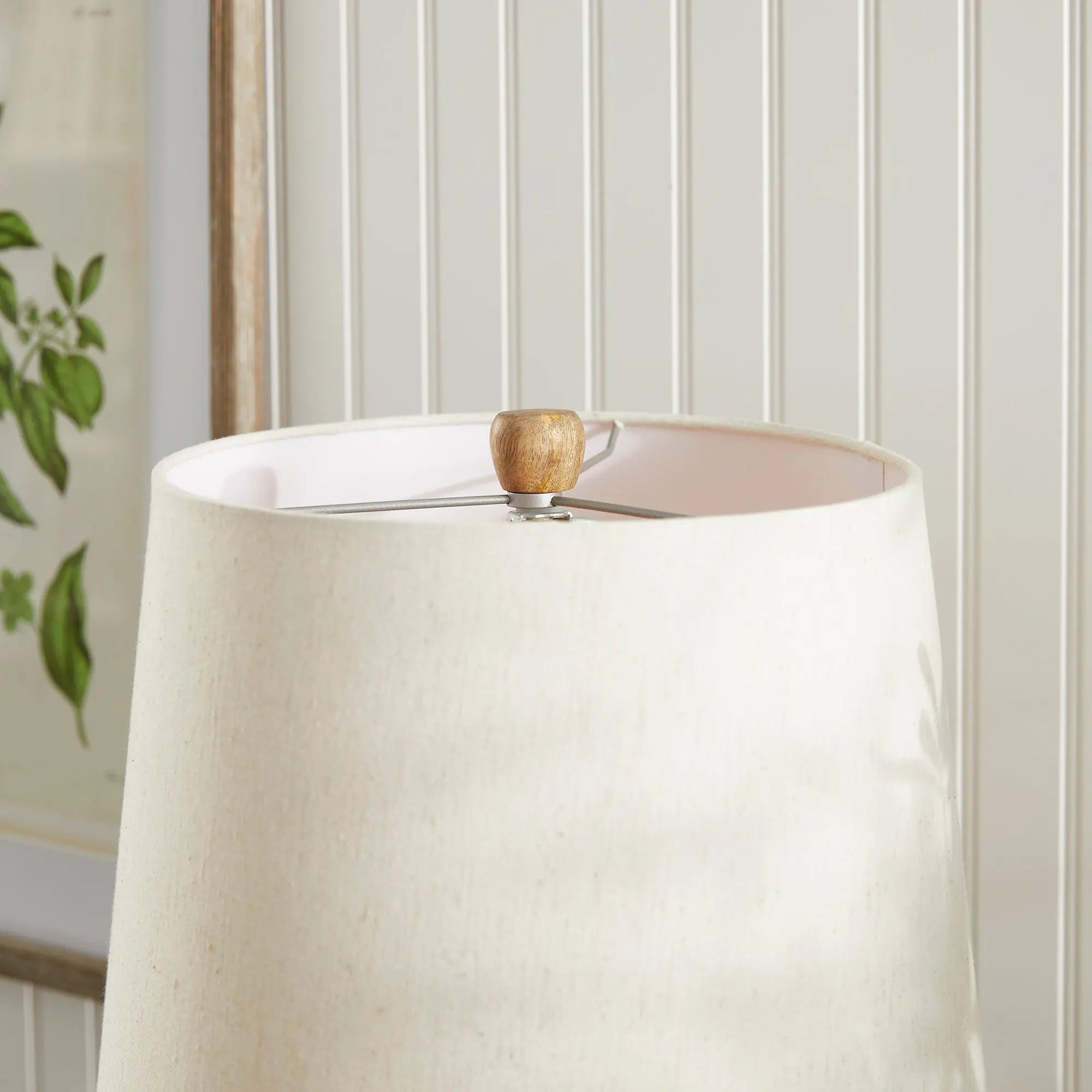 Adria Table Lamp with a textured, pitted, warm white ecomix base and a cream-colored tapered lamp shade. The lamp is shown from the front against a neutral background.