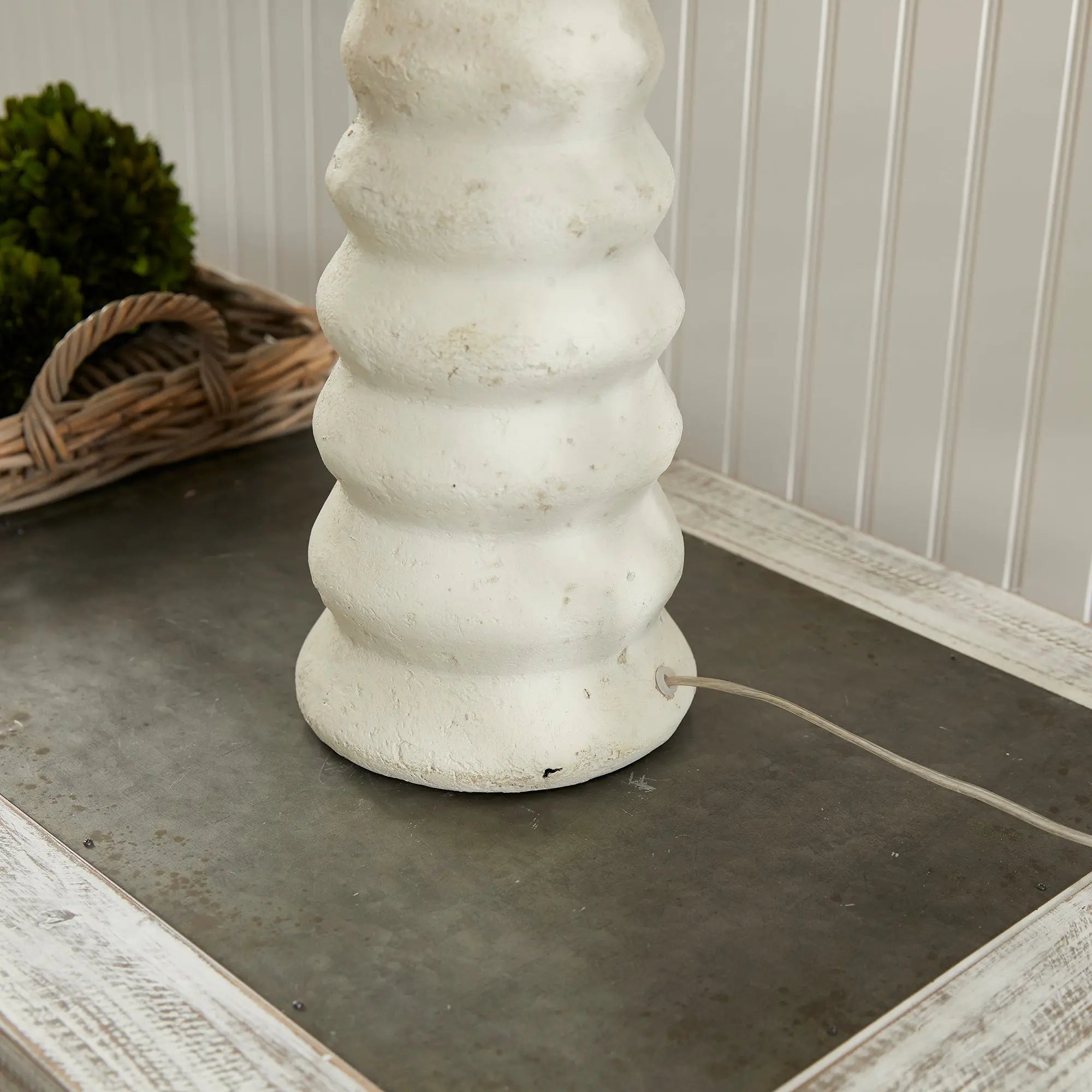 Adria Table Lamp with a textured, pitted, warm white ecomix base and a cream-colored tapered lamp shade. The lamp is shown from the front against a neutral background.