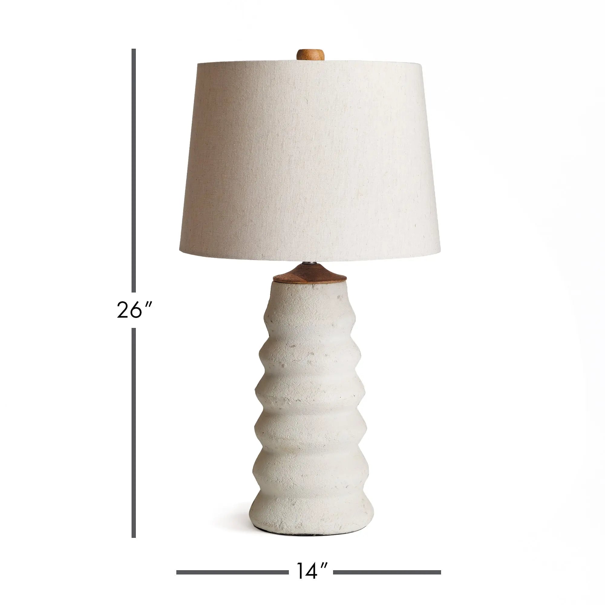 Adria Table Lamp with a textured, pitted, warm white ecomix base and a cream-colored tapered lamp shade. The lamp is shown from the front against a neutral background.