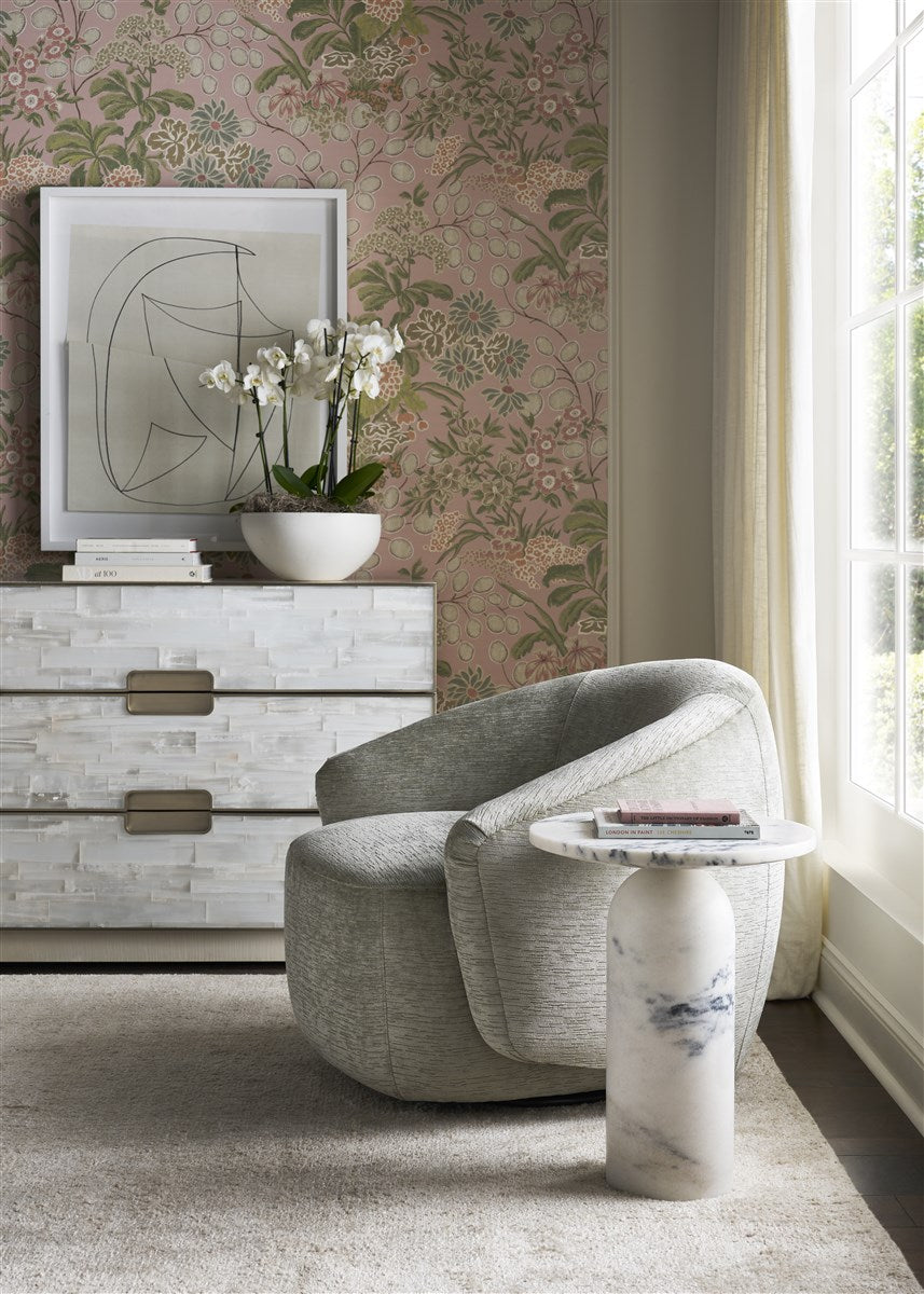 Modern living room with a gray armchair, marble side table, and floral wallpaper.