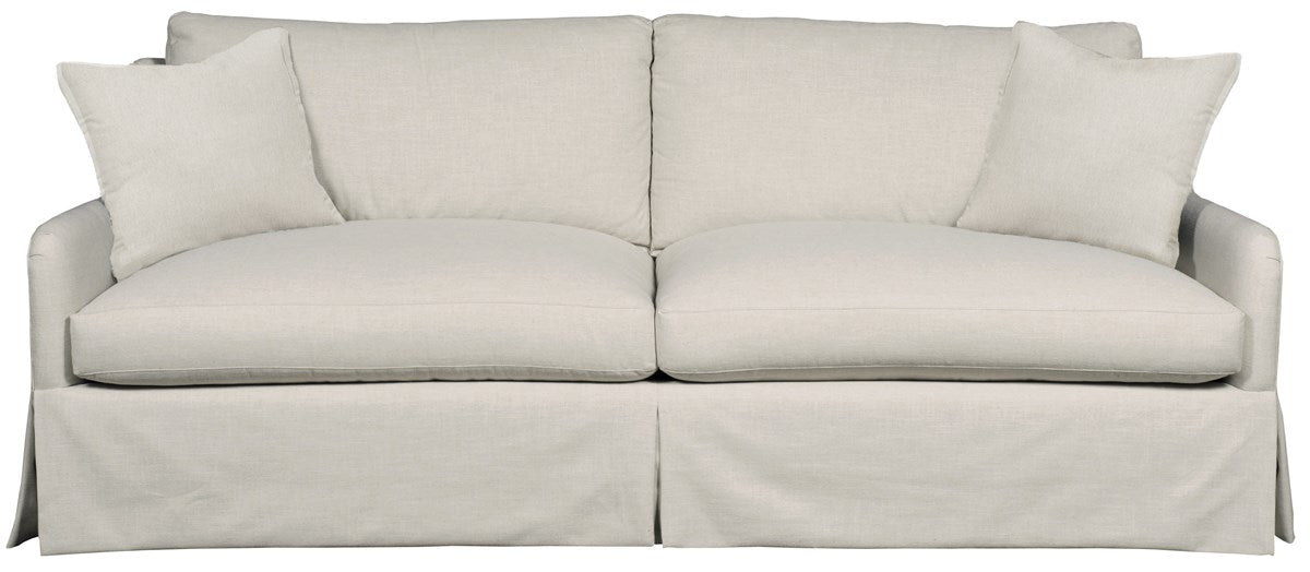 Fisher Sofa, a long, classic slipcovered sofa with a skirted base, deep cushions, and two throw pillows, upholstered in a light, neutral Nuzzle Linen fabric.