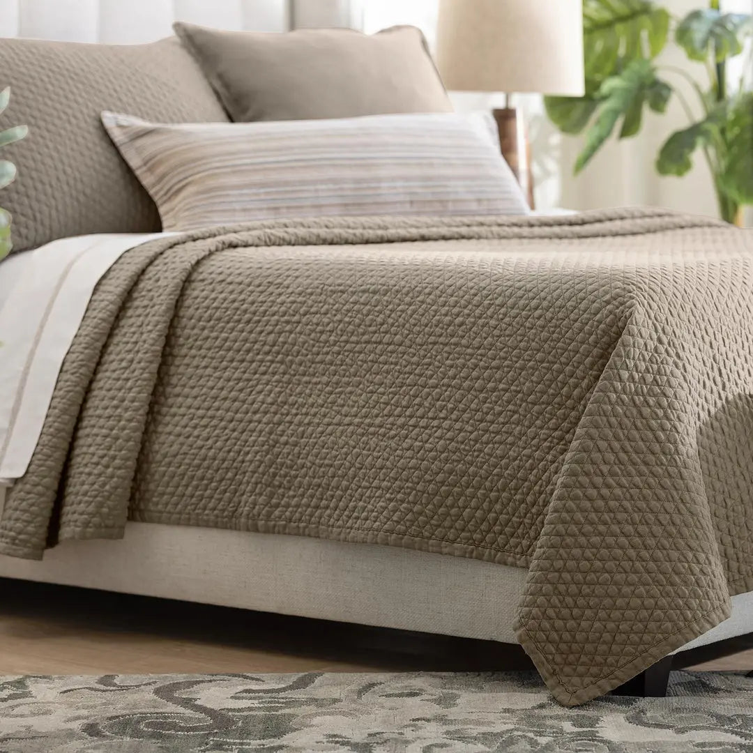 Dawn Diamond Quilted Queen Coverlet in the warm neutral trench coat color, showing the quilted texture and flange edge on a bed.