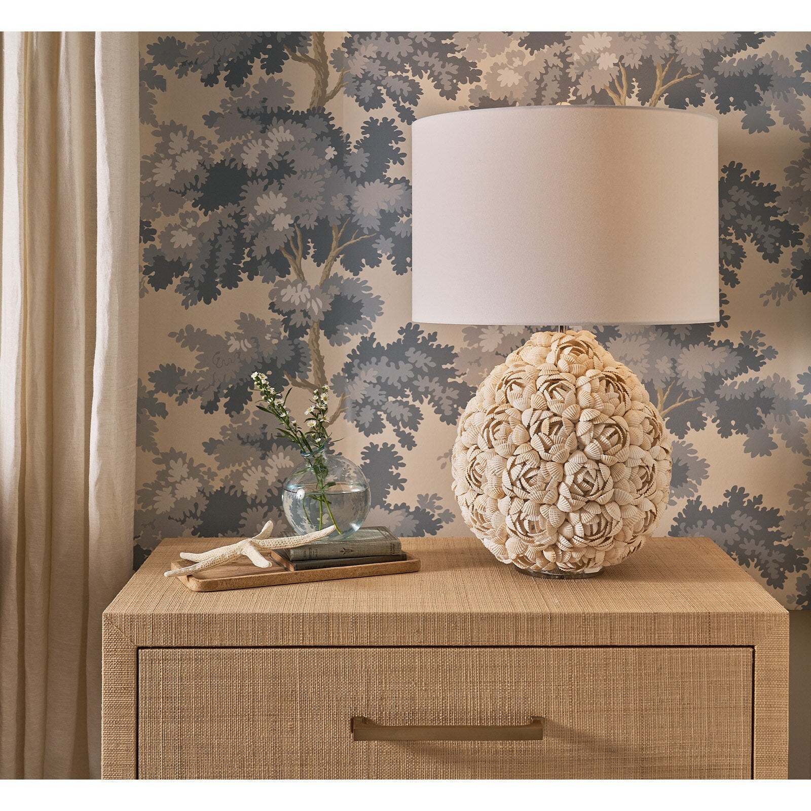 Decorative lamp on a wooden cabinet with floral wallpaper in the background