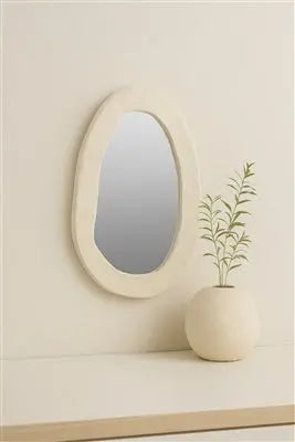 A large round wall mirror featuring a thick, textured off-white frame made from sustainable paper mache with a smooth, artisanal finish.