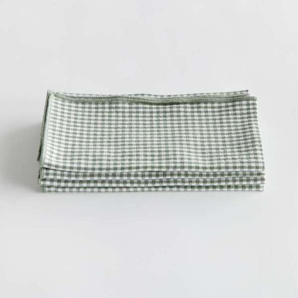Set of four Viola Dinner Napkins made from soft, verdant green cotton, folded and tied with a grosgrain ribbon.