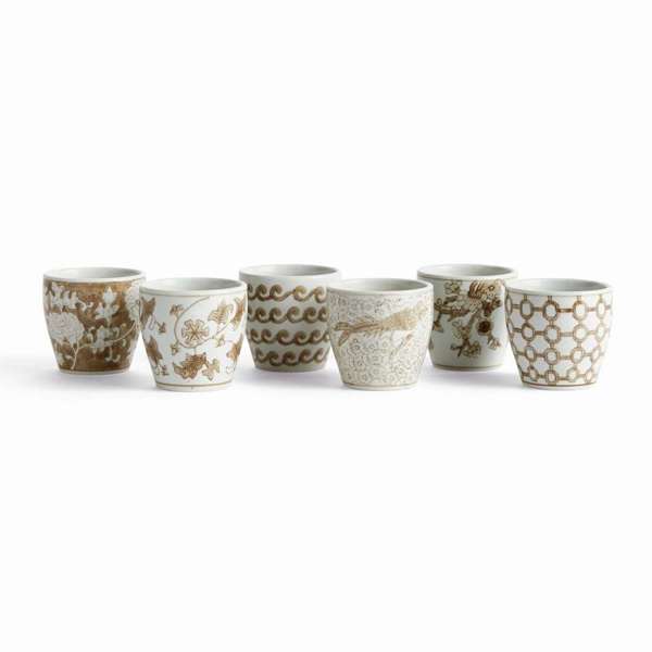 Set of six ceramic cups with decorative patterns on a white background