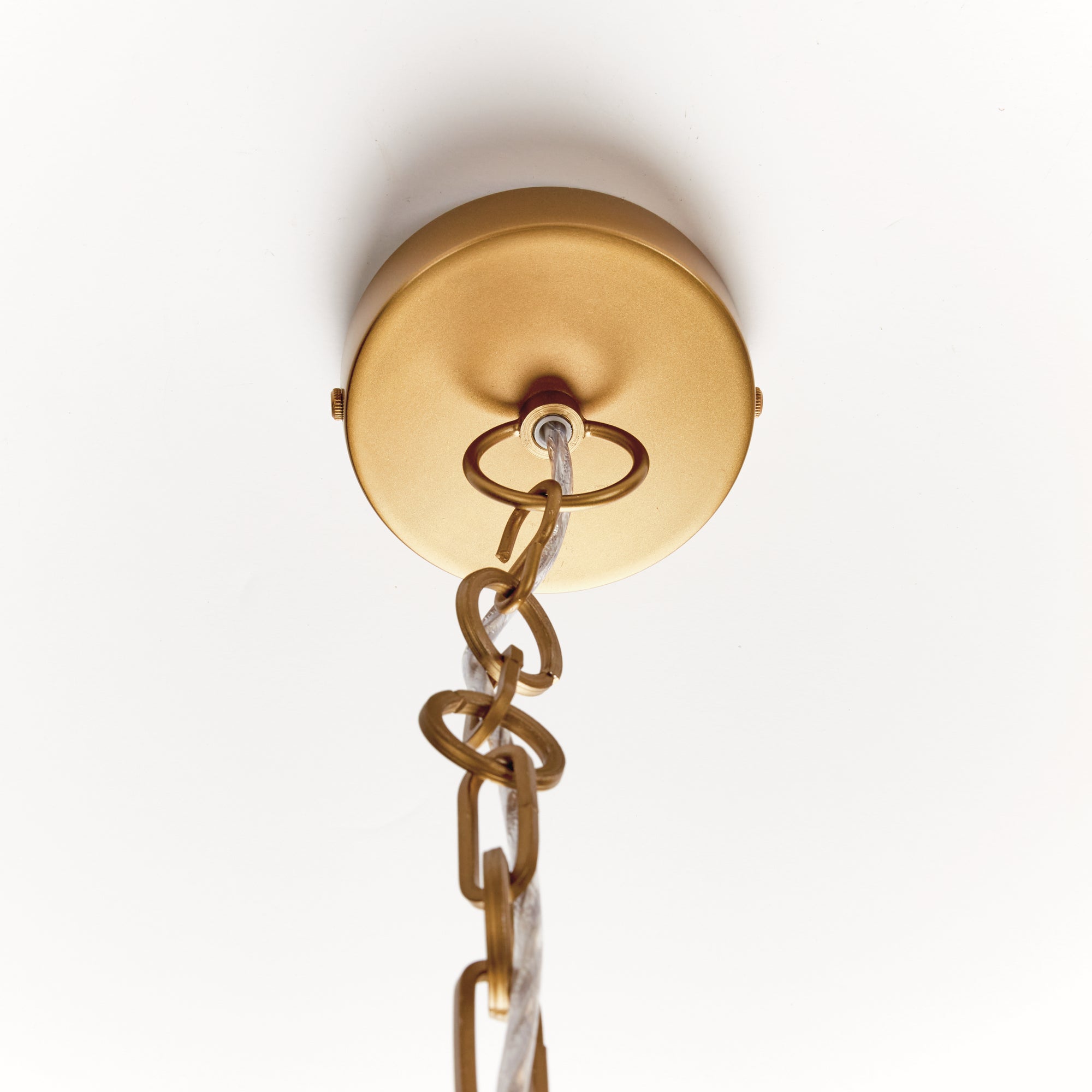 Close-up of a gold ceiling light fixture with chain on a white background
