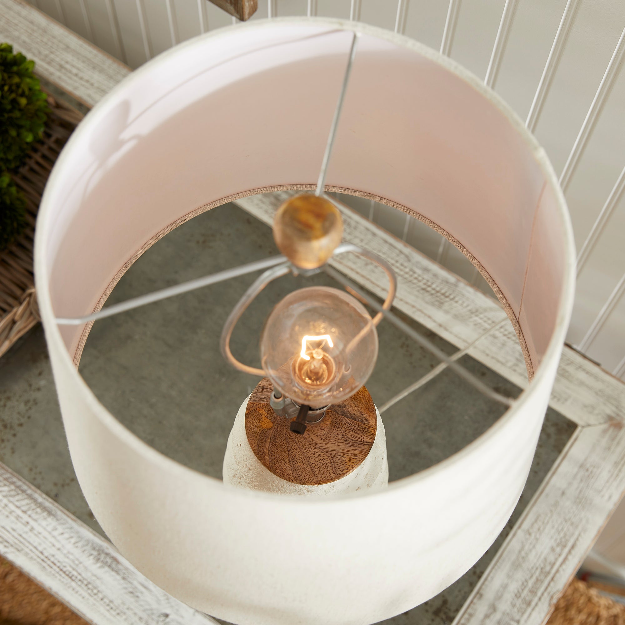 Adria Table Lamp with a textured, pitted, warm white ecomix base and a cream-colored tapered lamp shade. The lamp is shown from the front against a neutral background.