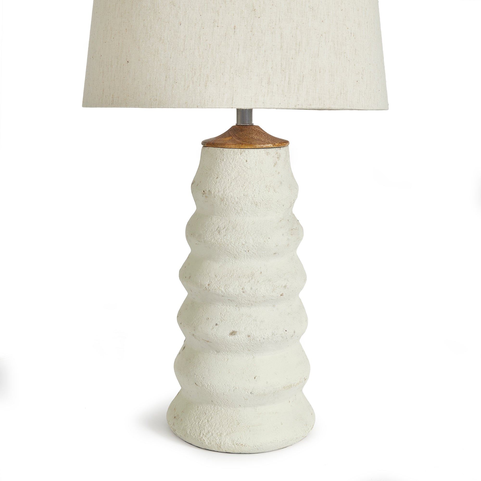 Adria Table Lamp with a textured, pitted, warm white ecomix base and a cream-colored tapered lamp shade. The lamp is shown from the front against a neutral background.